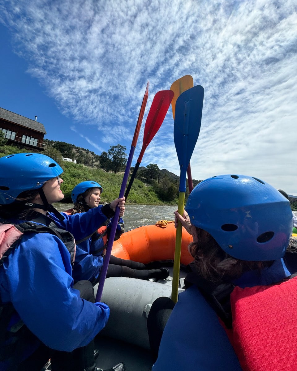 Troop 114G white water rafting holding paddles together